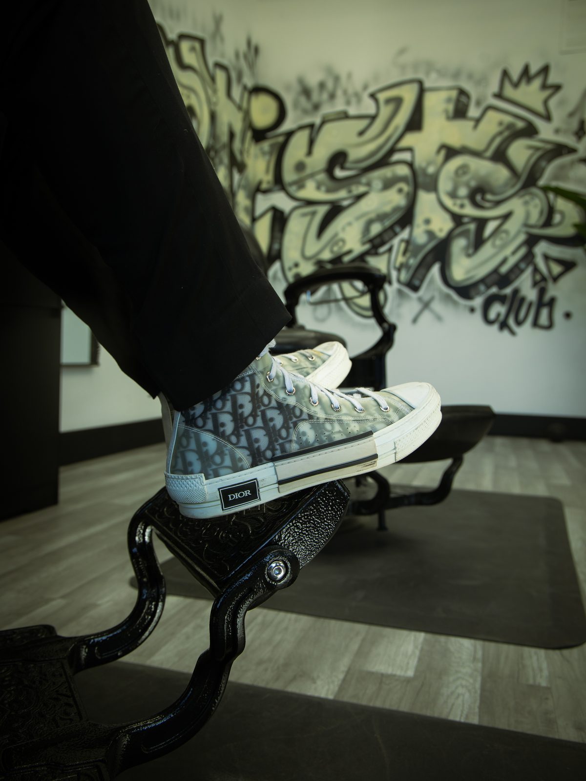 A client's trainers on the footrest against the graffiti wall
