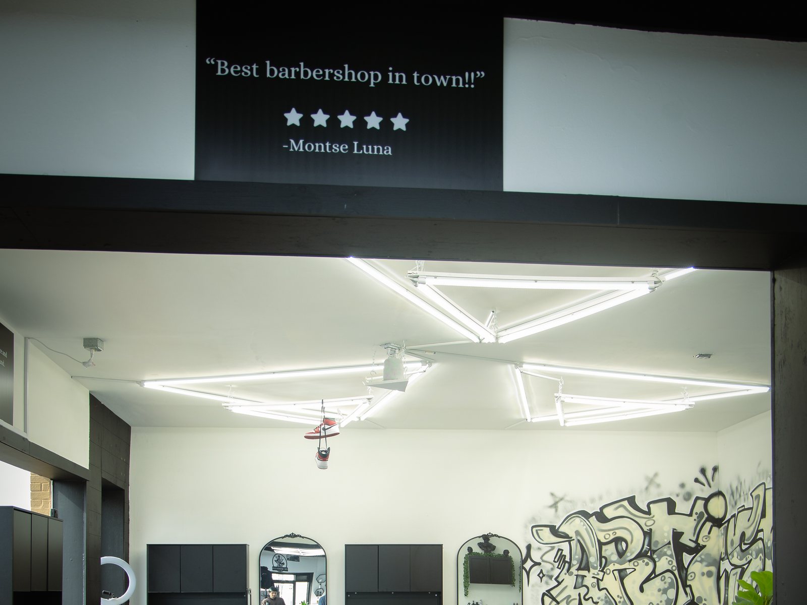 A framed five star customer review mounted on the wall above the shop floor